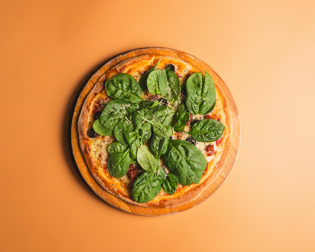 A pizza with spinach leaves on top of it