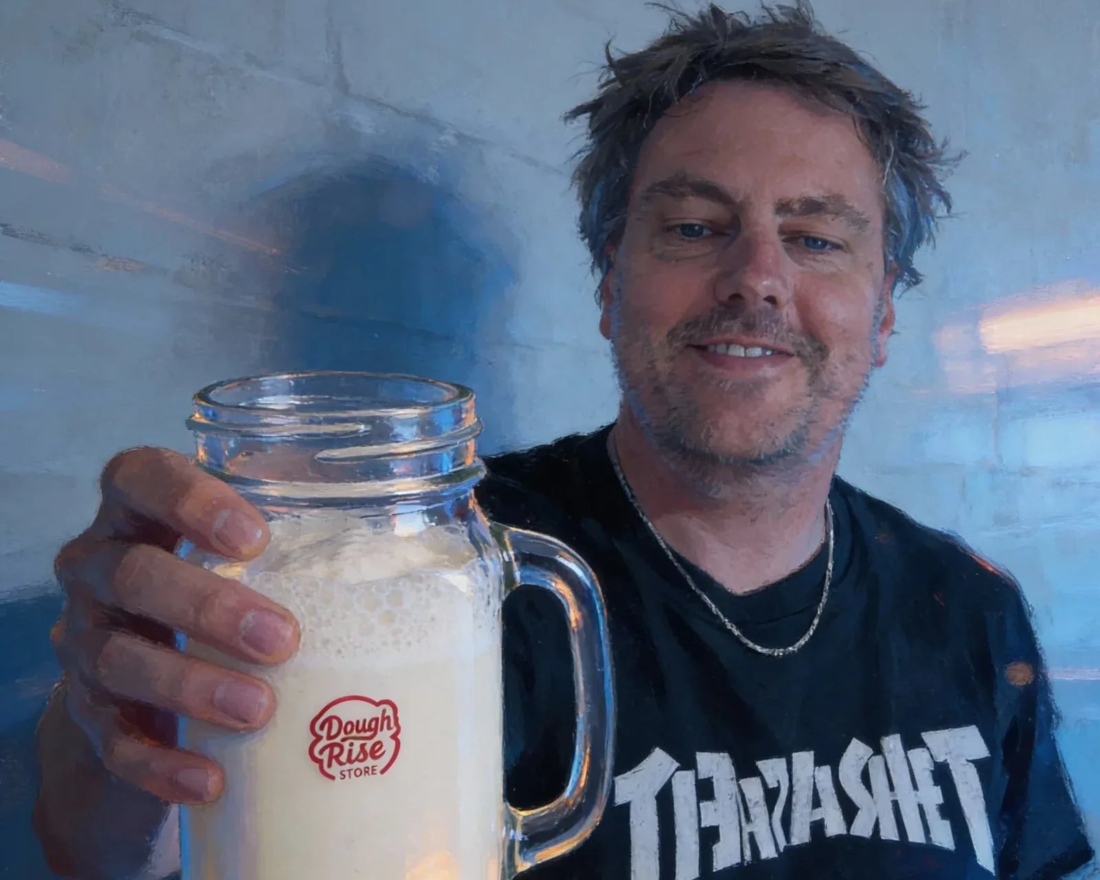Ben, founder of DoughRise, holding a sourdough starter in a mason jar