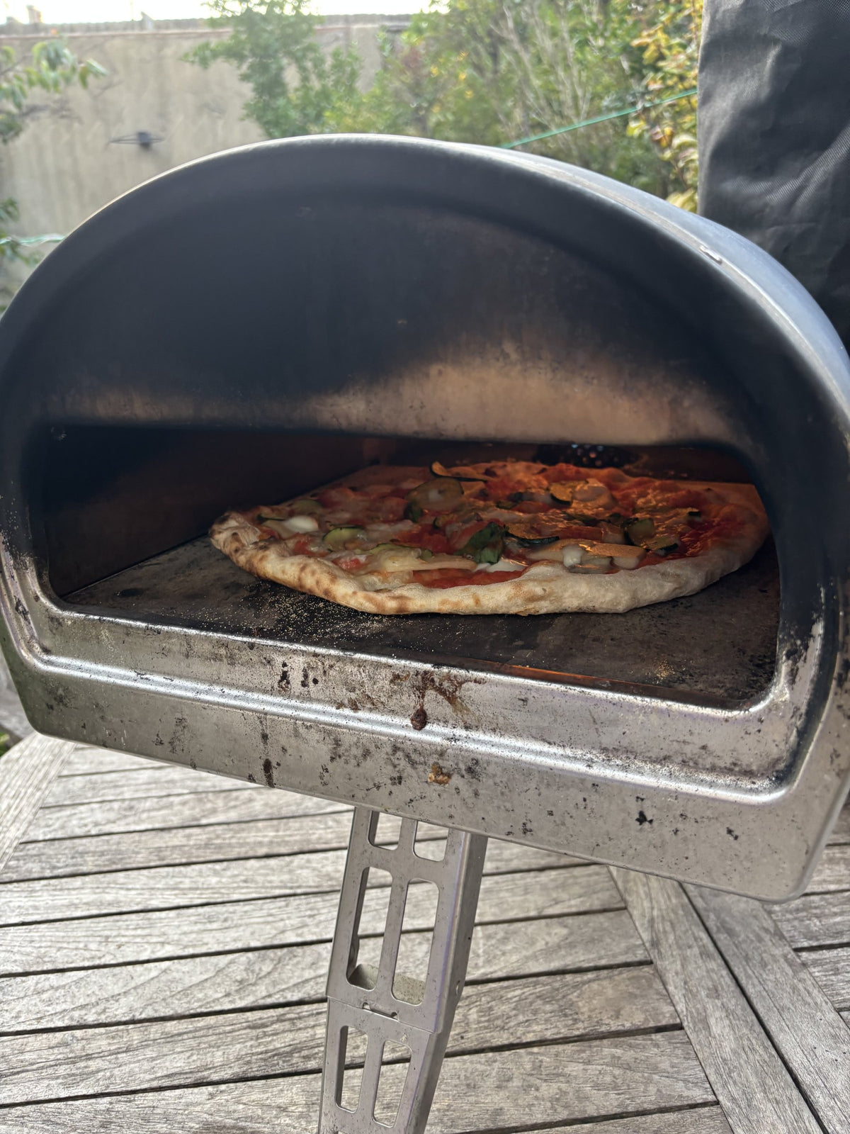 Pizza baking inside the Roccbox in the garden