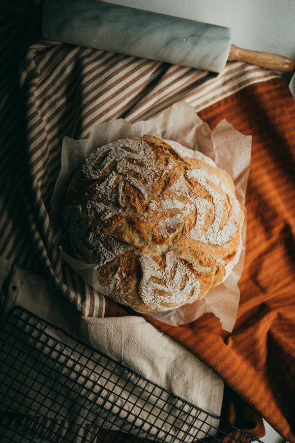 Scored sourdough loaf styled with a marble rolling pin and linen — The Everything Bundle