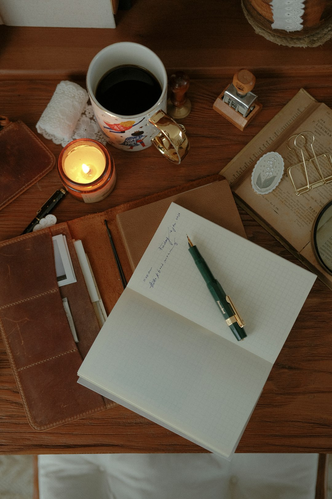 Open notebook and pen on a warm, candlelit desk — The Baker's Journal