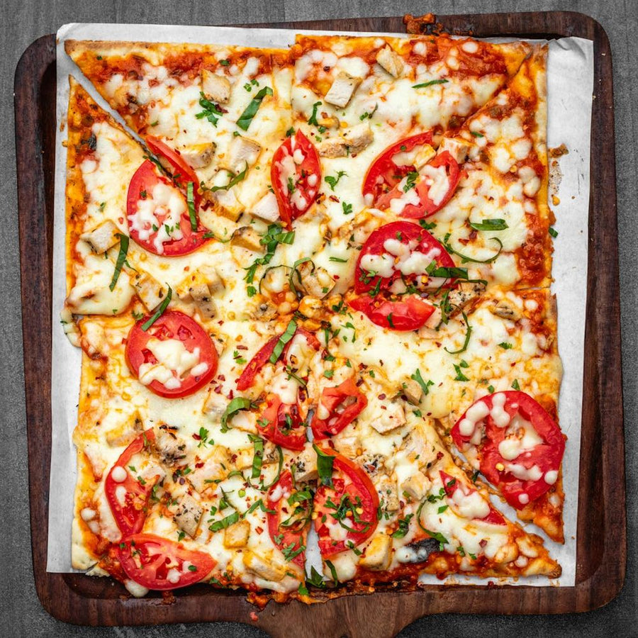 Square Detroit-style pan pizza with tomato sauce and cheese fried to the pan edge