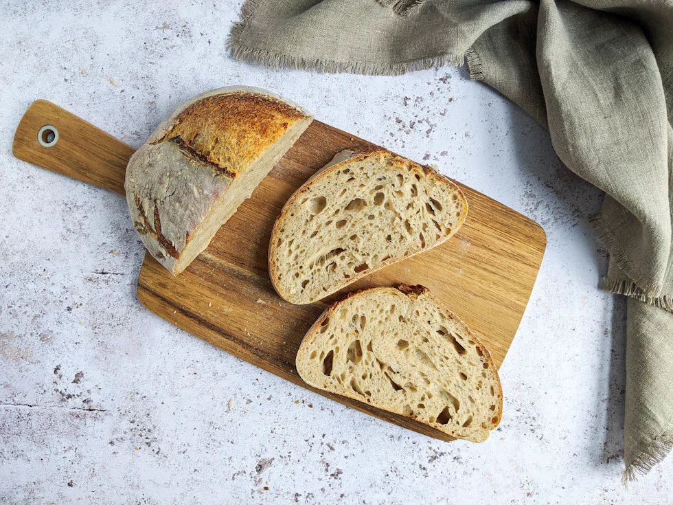 A sliced sourdough loaf showing an open, airy crumb