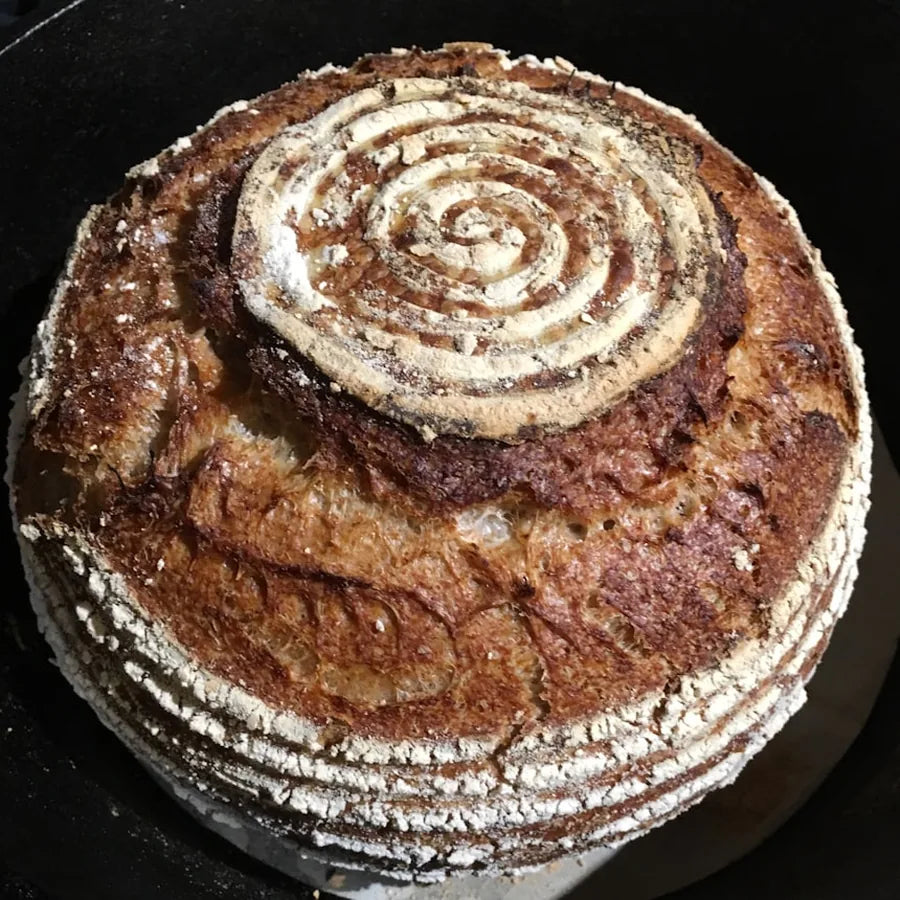 Baked sourdough loaf with a swirling spiral crust pattern